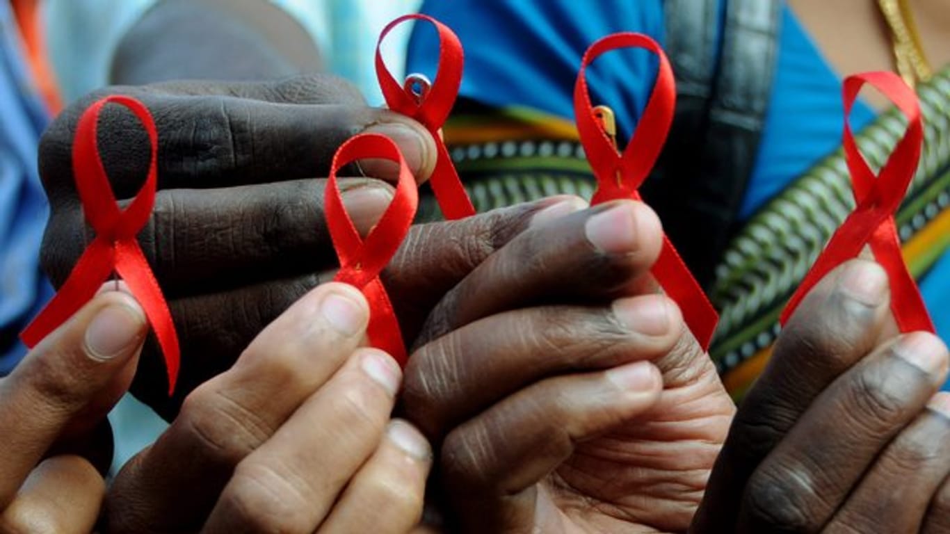 Indische Aktivisten halten am Welt-Aids-Tag rote Schleifen in den Händen.