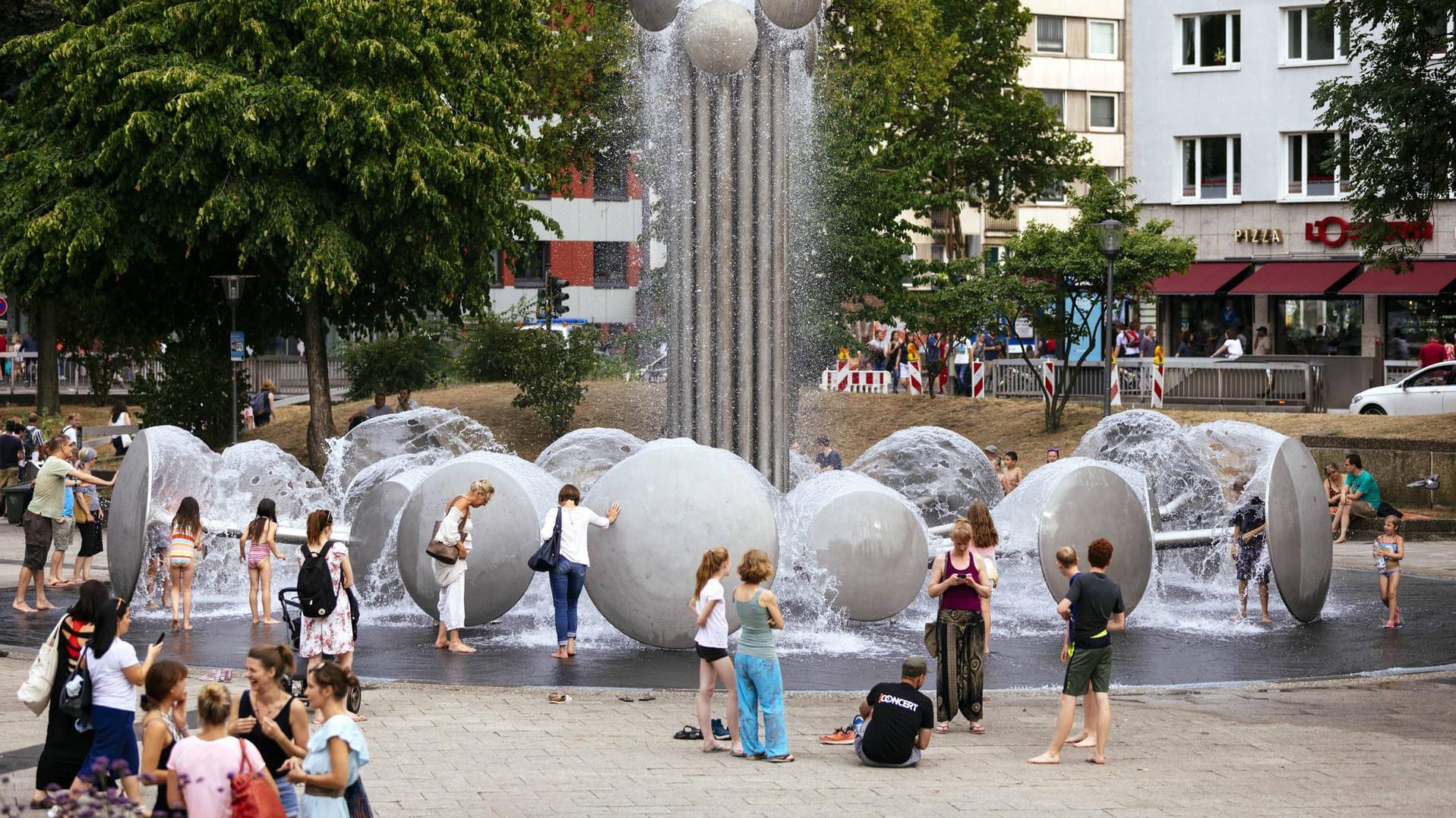 Brunnen auf dem Ebertplatz in Köln: Viele Menschen suchen während der Hitze Erfrischung an öffentlichen Wasserquellen.