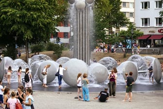 Brunnen auf dem Ebertplatz in Köln: Viele Menschen suchen während der Hitze Erfrischung an öffentlichen Wasserquellen.