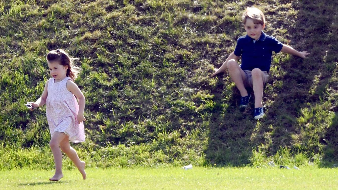 Spaß beim Spielen: Prinzessin Charlotte und Prinz George toben über eine Wiese.