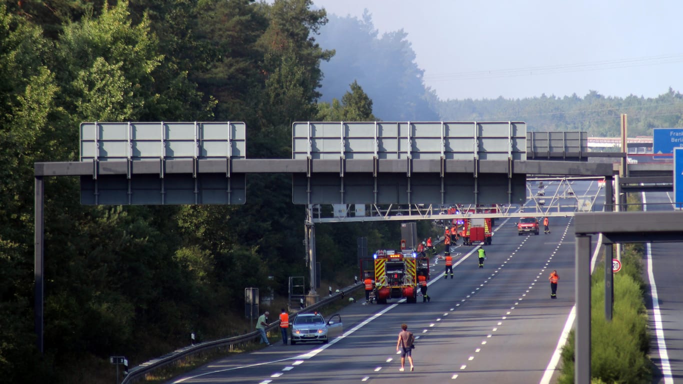 Feuerwehr im Großeinsatz auf abgesperrter Autobahn bei Potsdam: Großflächige Waldbrände zwingen die Behörden die Autobahnen auf weite Strecke für den Verkehr zu schließen.