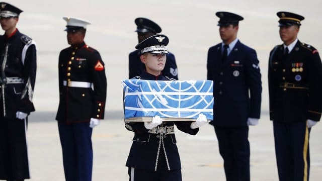 Ein Soldat trägt auf der Osan Air Base die Überreste eines amerikanischen Soldaten, der während des Koreakrieges 1950-53 umgekommen sein soll. Ein Soldat trägt auf der Osan Air Base die Überreste eines amerikanischen Soldaten, der während des Koreakrieges 1950-53 umgekommen sein soll.