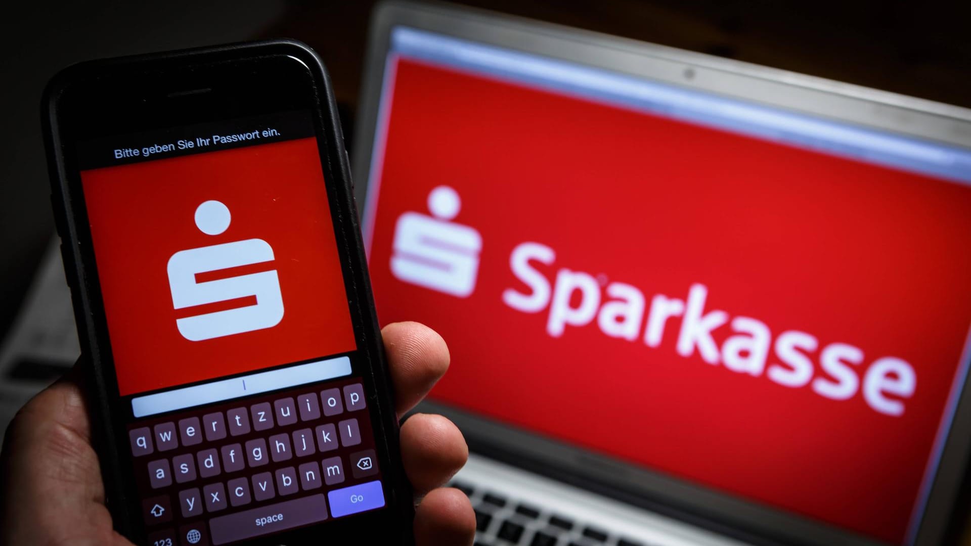 Sparkassen-Logo auf Smartphone und Laptop: Sparkassen-Kunden können demnächst kontaktlos per Smartphone bezahlen.