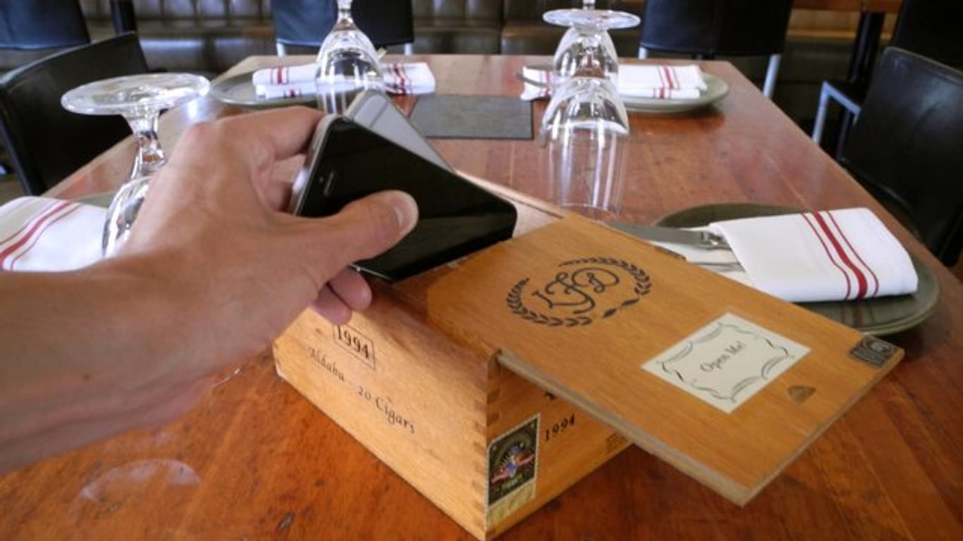 Ein Gast legt sein Handy in eine Zigarrenkiste im Restaurant Hearth in New York.