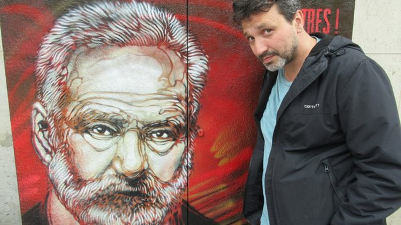 Christian Guemy, Streetart-Künstler und bekannt unter dem Pseudonym C215, neben seinem Portrait von Victor Hugo.