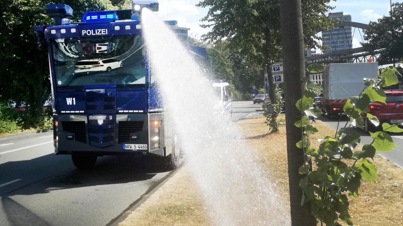 Ein Wasserwerfer der Polizei bewässert in Wuppertal Bäume: Auch in vielen Orten Nordrhein-Westfalens war es besonders heiß.