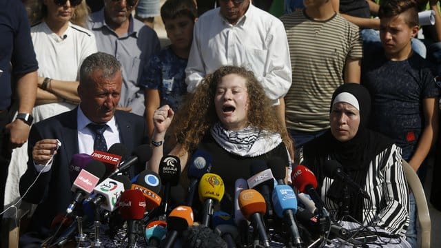 Ahed Tamimi sitzt zwischen ihrem Vater Bassam und ihrer Mutter Nariman und gibt eine Pressekonferenz. Ahed Tamimi sitzt zwischen ihrem Vater Bassam und ihrer Mutter Nariman und gibt eine Pressekonferenz.