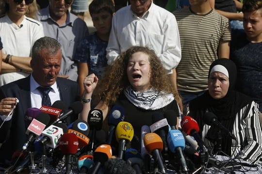 Ahed Tamimi sitzt zwischen ihrem Vater Bassam und ihrer Mutter Nariman und gibt eine Pressekonferenz.