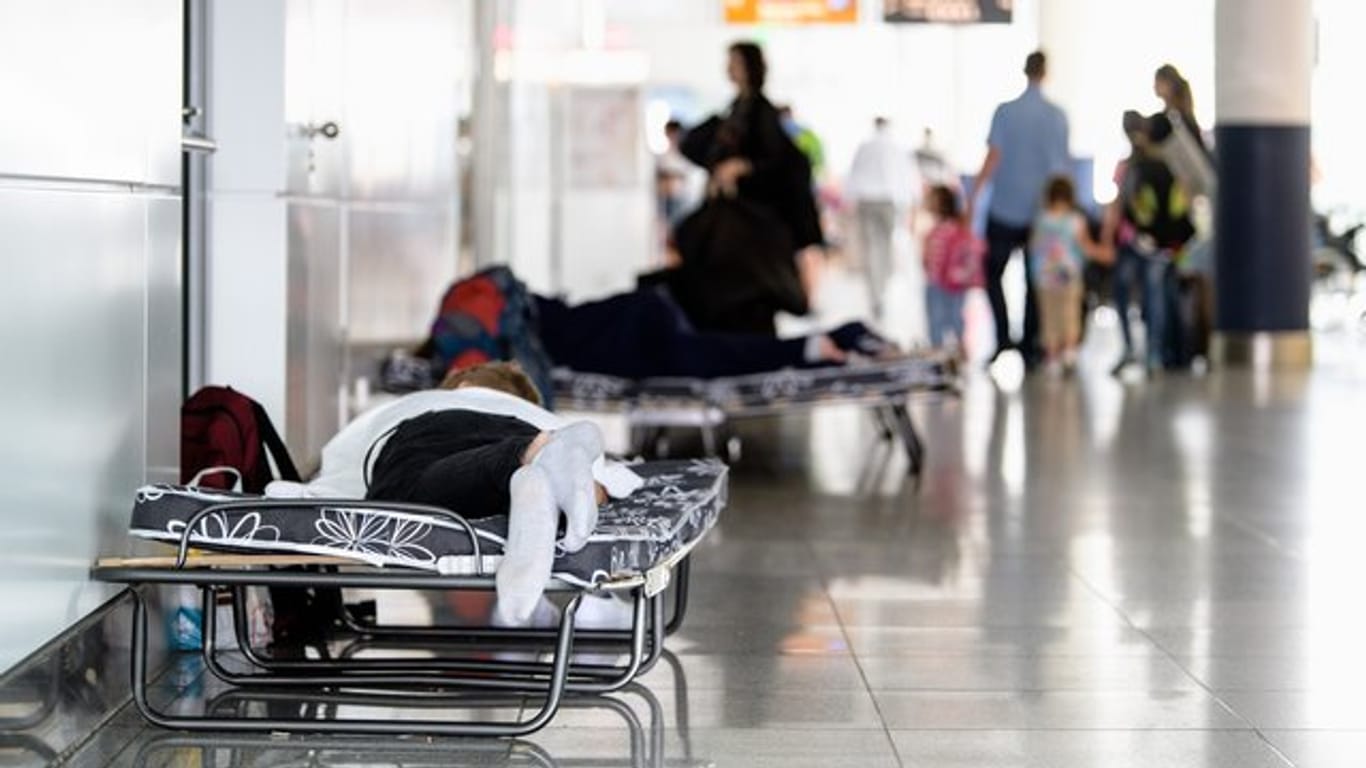 Fluggäste schlafen auf Klappbetten: Nach einem Polizeieinsatz am Vortag mit mehr als 200 ausgefallenen Flügen sind die Konsequenzen am Terminal 2 am Flughafen München noch immer spürbar.