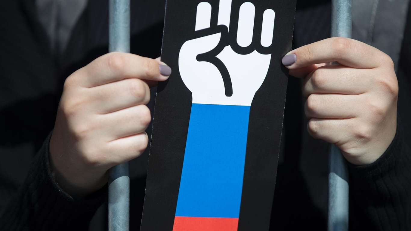 Eine Frau hält ein Schild mit einer geballten Faust hoch: Die Rentenpläne der russischen Regierung sind heikel für die Führung.