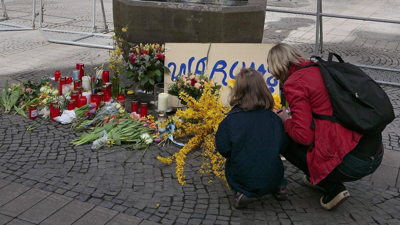 Menschen legen vor der Gaststätte Kiepenkerl in Münster Blumen nieder: Vier Monate nach der Amokfahrt von Münster ist ein weiteres Opfer zu beklagen.