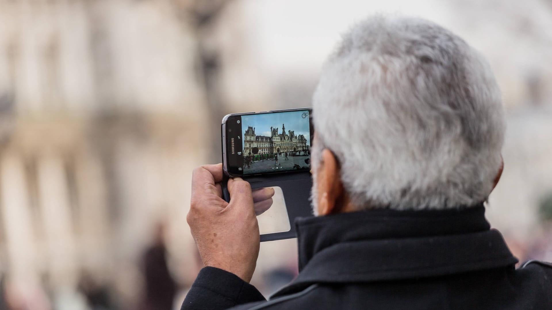 Ein Mann fotografiert ein Gebäude: Beim Ablichten von Gebäuden gelten besondere Regelungen.