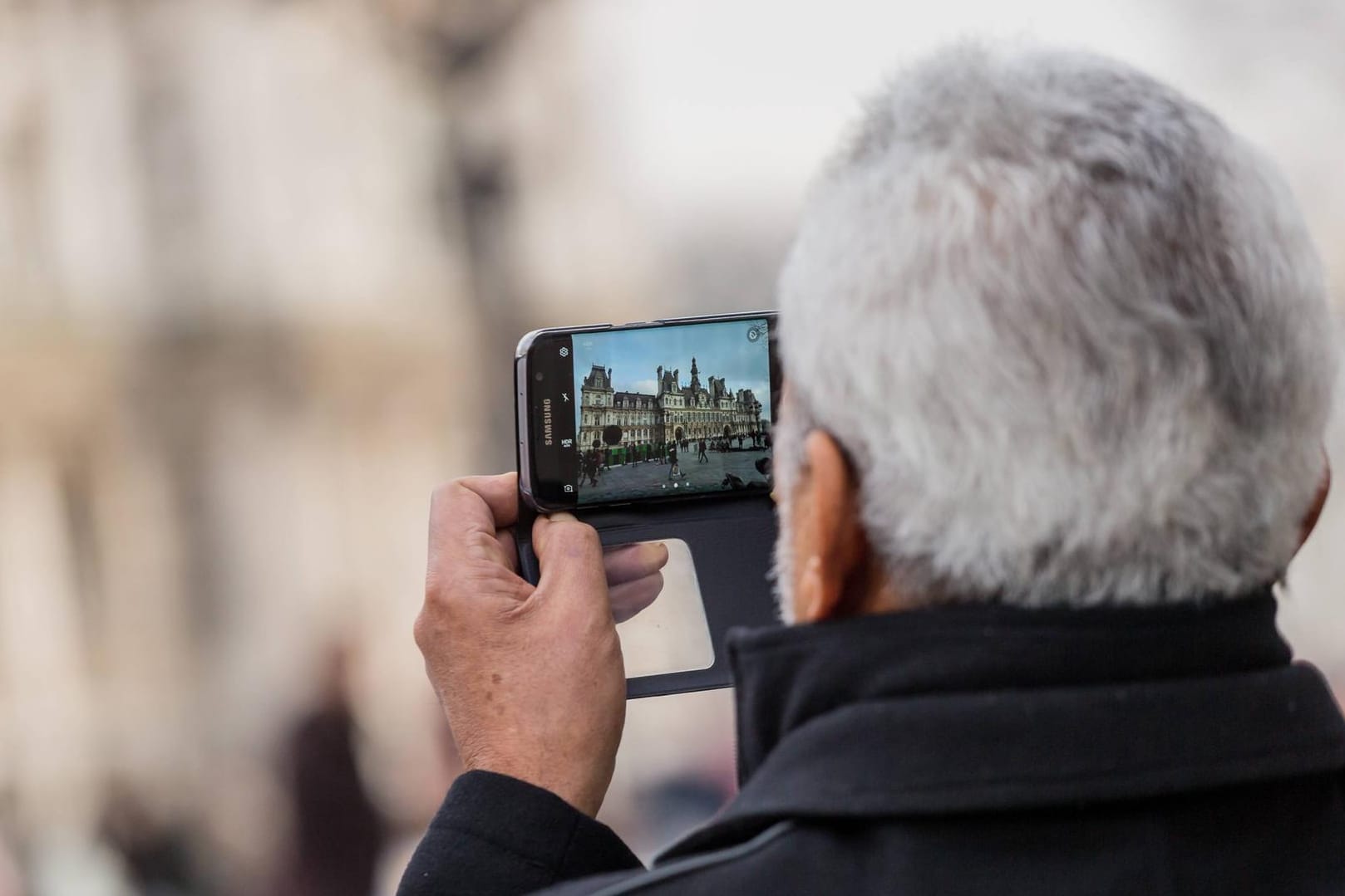 Ein Mann fotografiert ein Gebäude: Beim Ablichten von Gebäuden gelten besondere Regelungen.