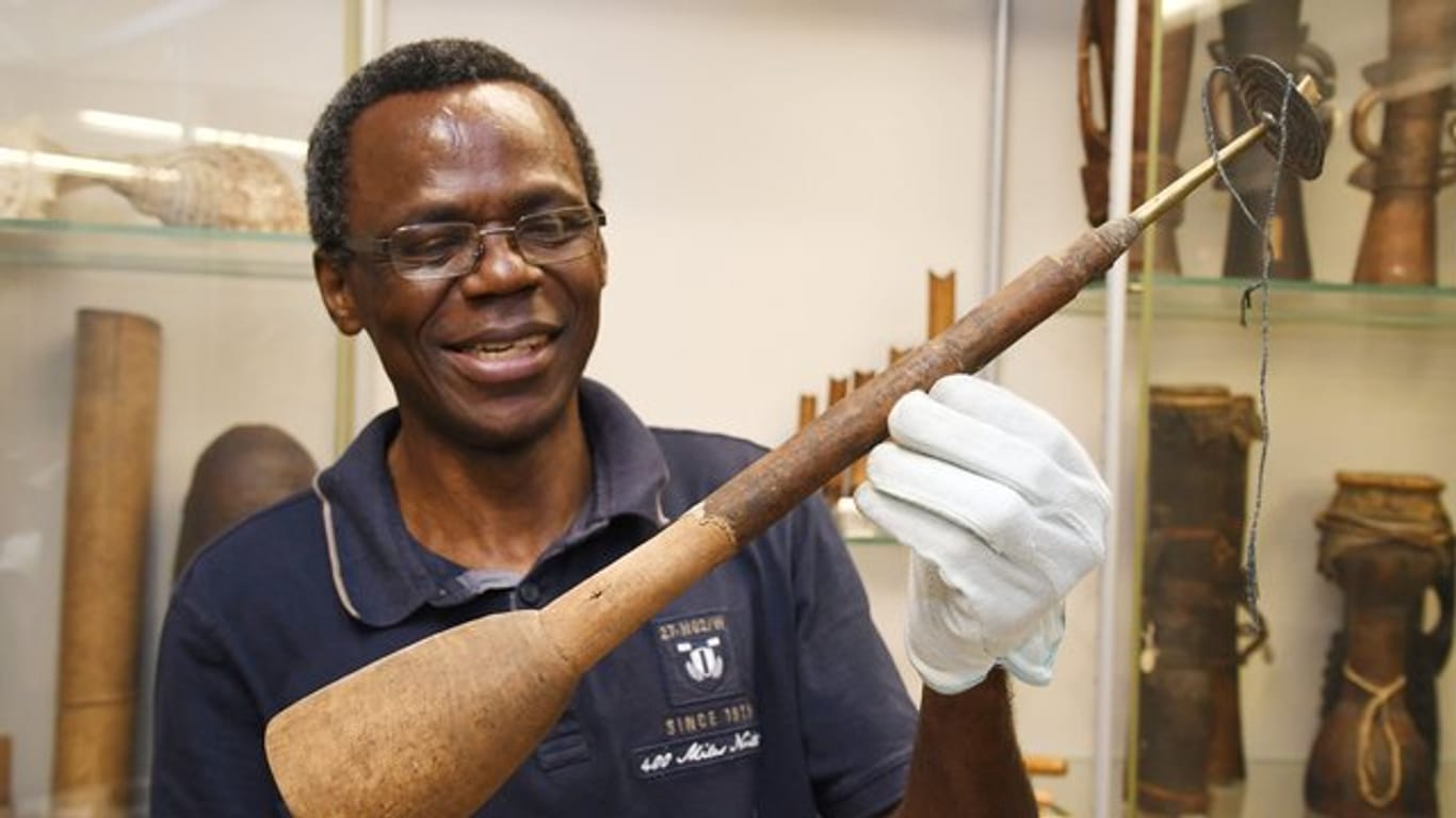 Der Wissenschaftler Ndzodo Awono zeigt im Übersee-Museum eine Schalmai aus Kamerun.