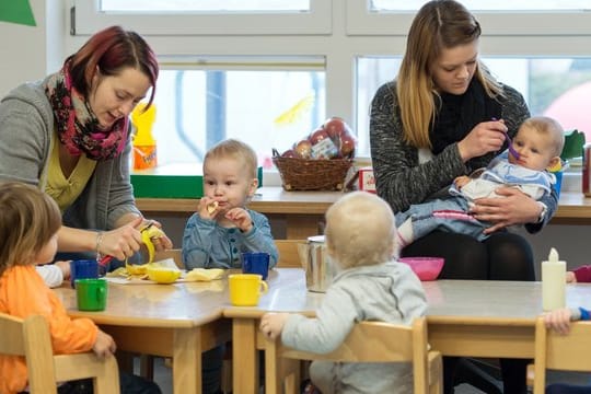 Die kleinsten Kinder des AWO Kindergartens "Diesterweg" in Lübbenau (Brandenburg) sitzen beim Essen.