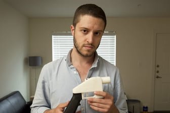 Der Gründer von Defense Distributed steht mit einer Kunststoff-Pistole aus einem 3D-Drucker in seinem Haus.