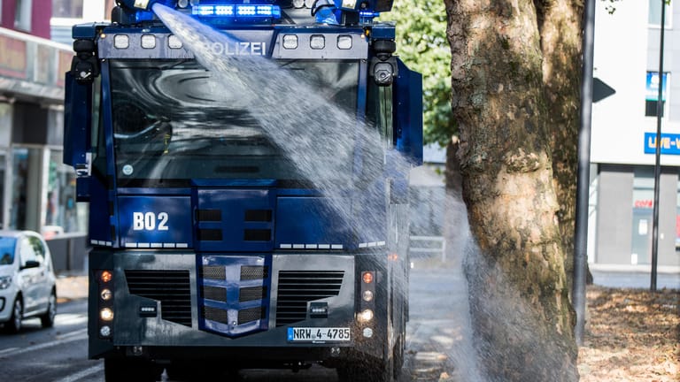 Ein Wasserwerfer der Polizei bewässert Bäume in Bochum.