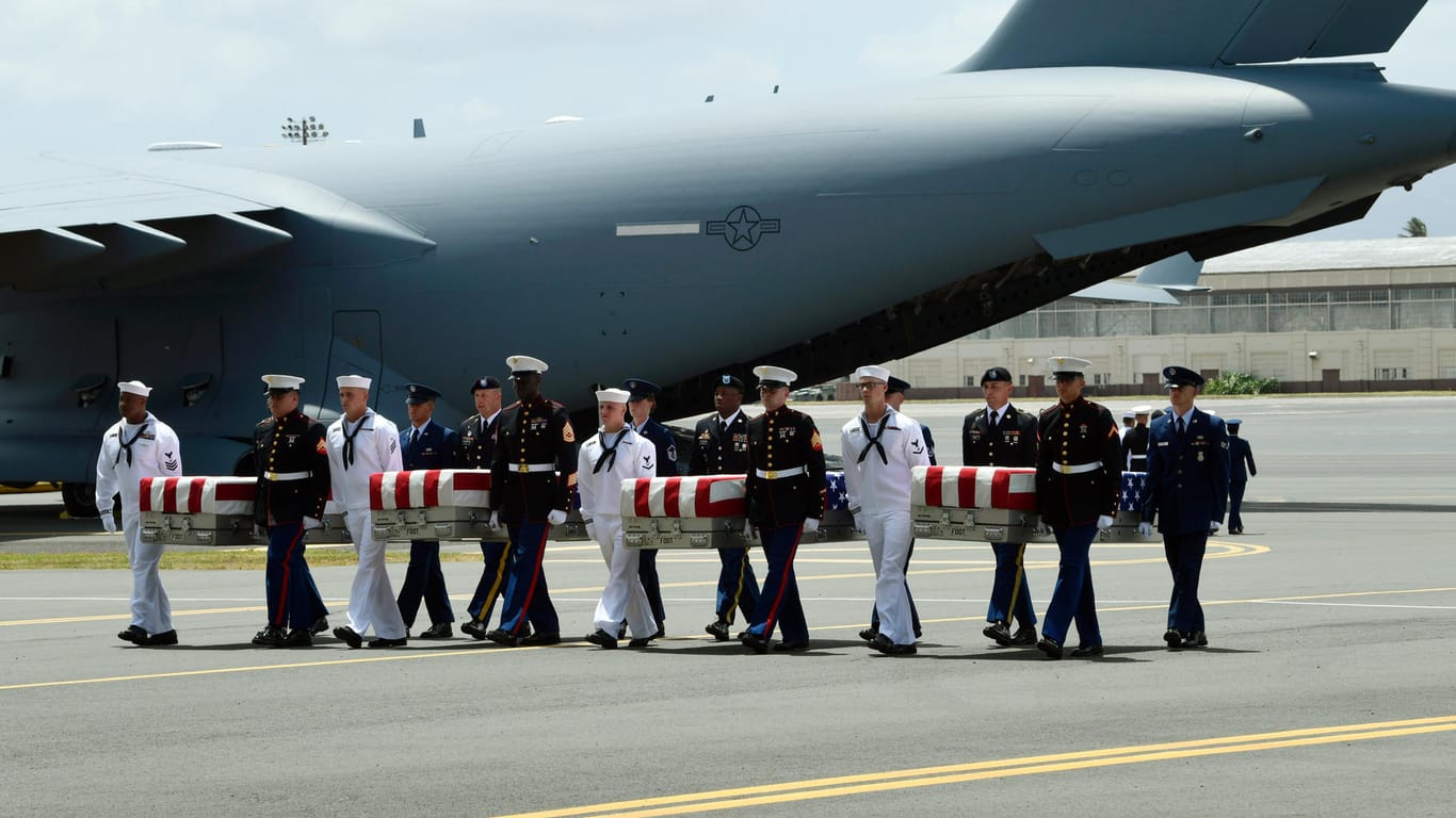 Militärs tragen während einer Empfangszeremonie die sterblichen Überreste mutmaßlicher im Korea-Krieg gefallener US-Soldaten: US-Vizepräsident Pence hat auf Hawaii 55 Särge mit sterblichen Überresten in Empfang genommen.
