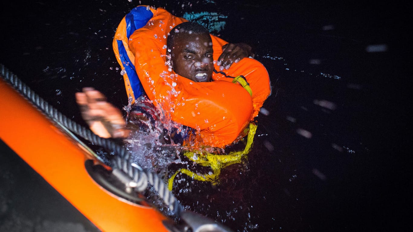 Ein Migrant schwimmt auf ein Rettungsschiff vor der Küste Libyens zu: Eine vernünftige Politik kann die derzeitige Flüchtlingssituation bewältigen, sagt Experte Gerald Knaus.