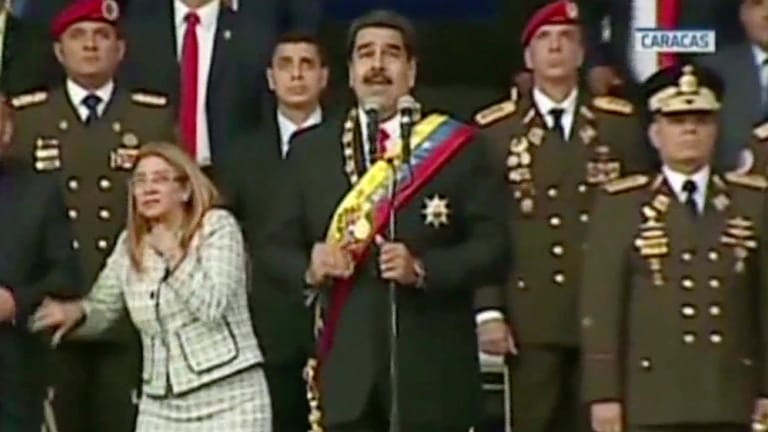 Präsident Nicolas Maduro spricht in Caracas, Venezuela, während seine Frau Cilia Flores auf eine Explosion reagiert: Bei dem mutmaßlichen Attentat blieb Maduro unverletzt.