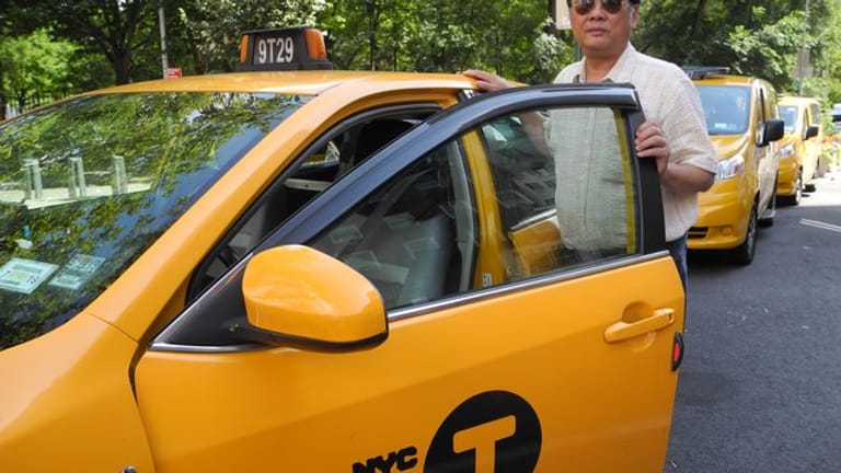 Richard Chow steht neben seinem Taxi - einem klassischen Yellow Cab.