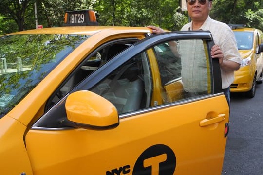 Richard Chow steht neben seinem Taxi - einem klassischen Yellow Cab.