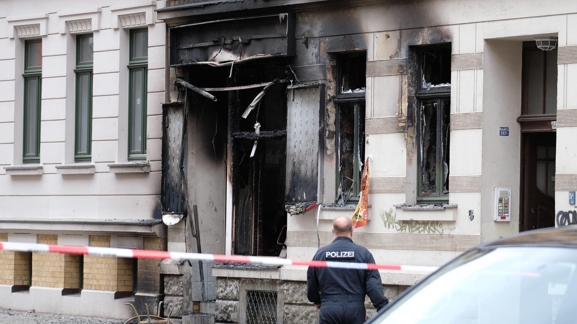 Ein Polizist steht vor einem Mehrfamilienhaus, in dem sich eine Explosion ereignete: Einen technischen Defekt schließt die Polizei bereits aus.