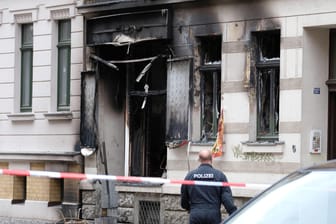 Ein Polizist steht vor einem Mehrfamilienhaus, in dem sich eine Explosion ereignete: Einen technischen Defekt schließt die Polizei bereits aus.