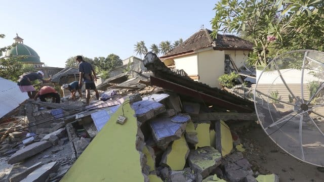 Dorfbewohner retten Gebrauchsgegenstände aus einem zerstörten Haus. Dorfbewohner retten Gebrauchsgegenstände aus einem zerstörten Haus.