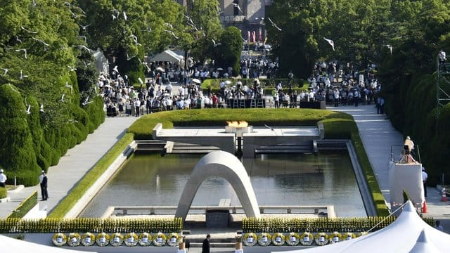 Tauben fliegen während einer Gedenkzeremonie über dem Kenotaph in Hiroshima.