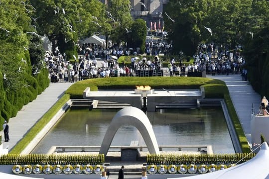 Tauben fliegen während einer Gedenkzeremonie über dem Kenotaph in Hiroshima.