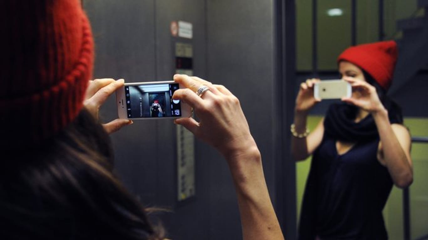 Frau macht ein Selfie: Bearbeitete Fotos können dazu führen, dass Menschen den Bezug zur Realität verlieren.