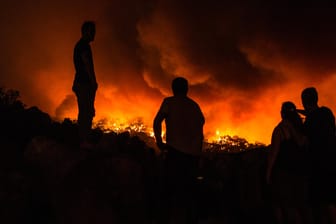 Menschen stehen in der Nähe eines Waldbrandes nahe der Kleinstadt Monchique: 1000 Einsatzkräfte kämpfen in Portugal gegen die Flammen.