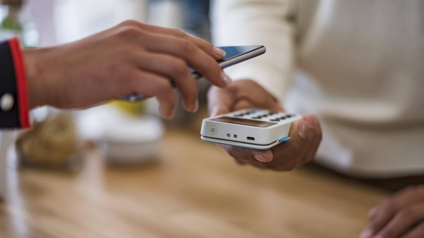 Kunde bezahlt per Smartphone: Ab dem 13. August wird von 85 Prozent aller 915 Volks- und Raiffeisenbanken das Bezahlen mit dem Handy ermöglicht.