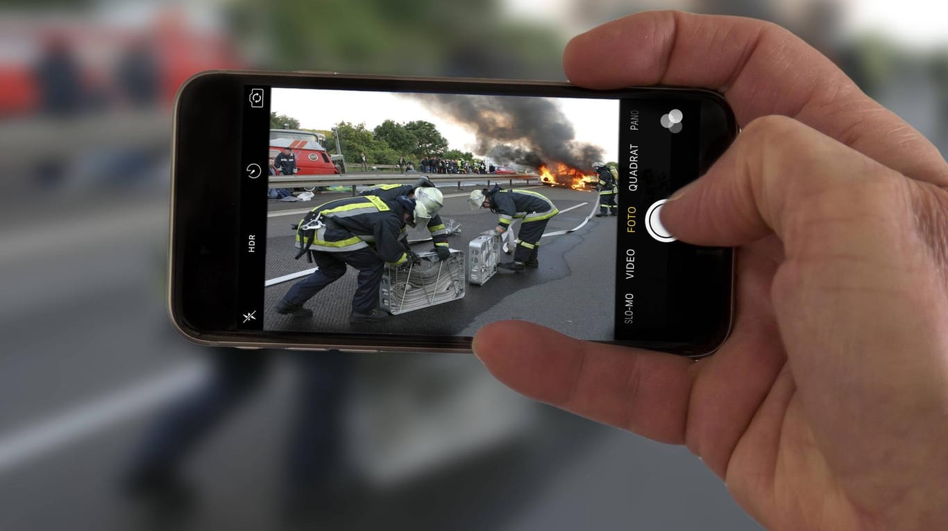 Ein Passant filmt einen Unfall mit dem Smartphone: Gaffer behindern immer wieder mit Ihrem Verhalten Rettungskräfte.
