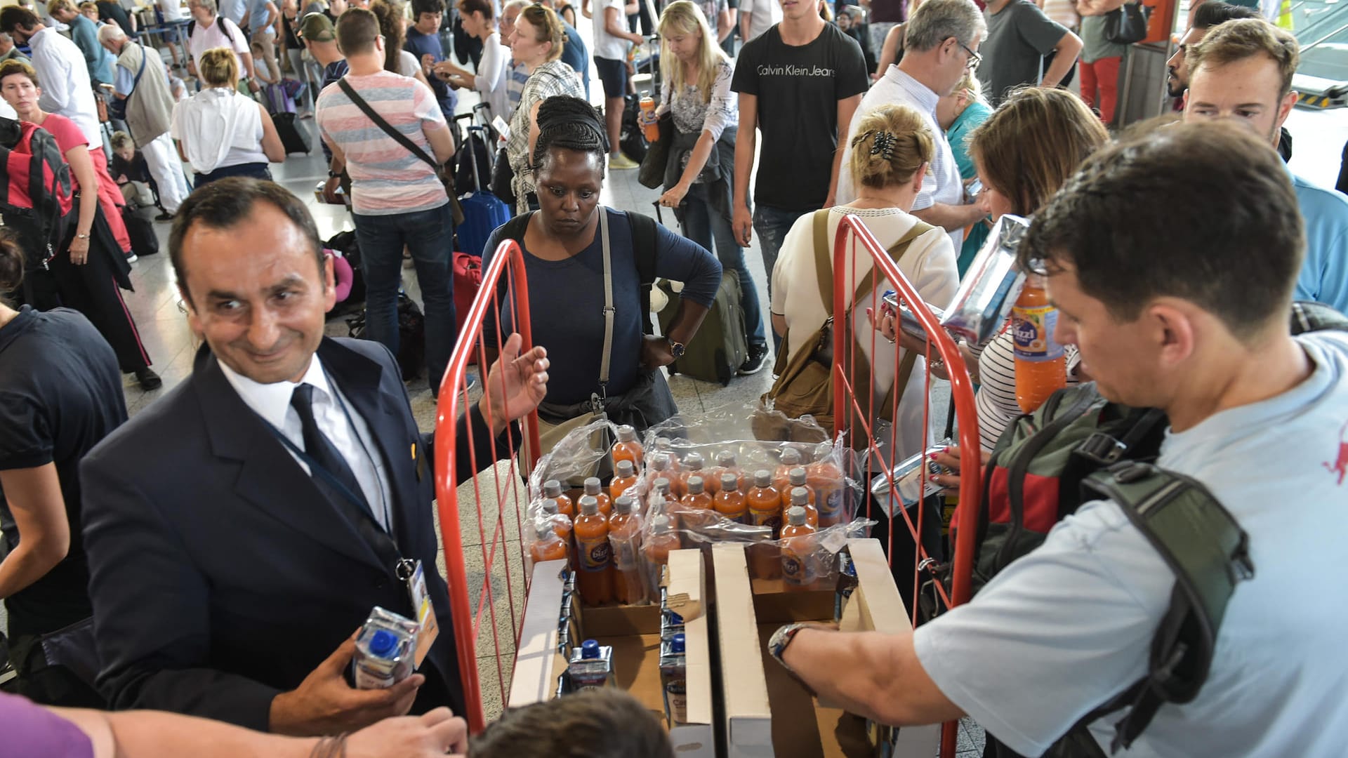 Passagiere in Halle A im Terminal 1 des Flughafens Frankfurt werden mit Getränken versorgt.