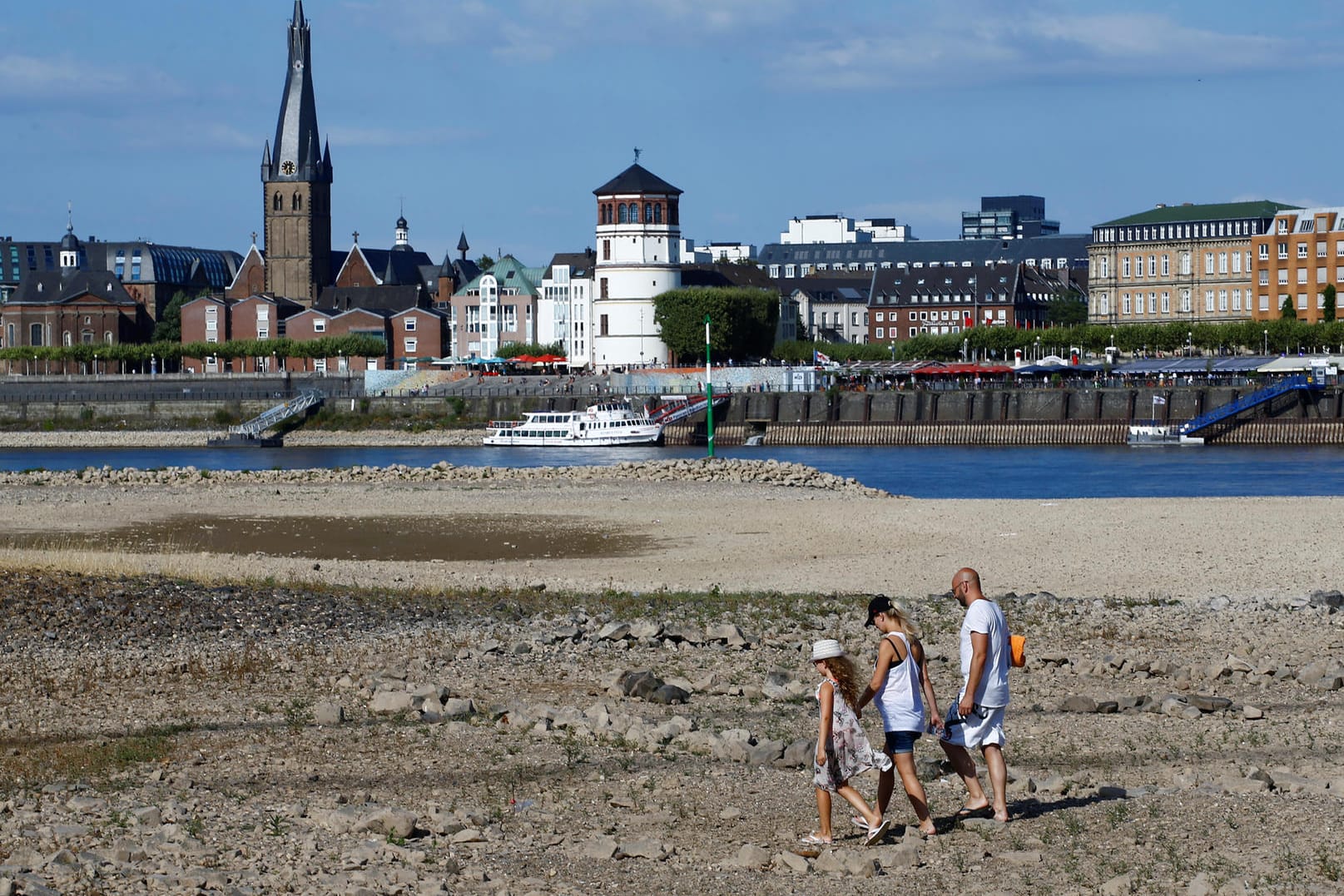 Dürresommer 2018 in Deutschland: Eine Familie läuft in Düsseldorf über ausgetrocknete Teile des Flussbetts des Rheins.