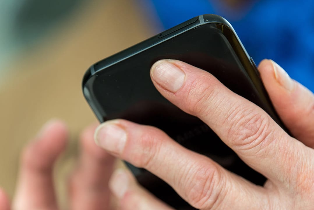 Eine Frau tippt auf ihrem Smartphone: Die Polizei hat verschiedene Möglichkeiten, ein Gerät zu orten. (Symbolbild)