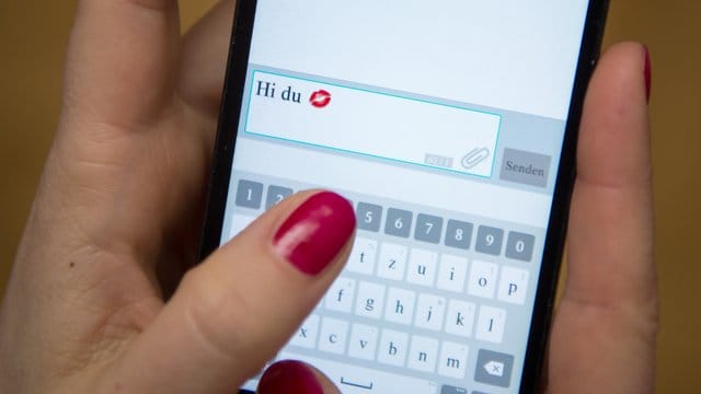 Eine Frau tippt auf einem Smartphone.