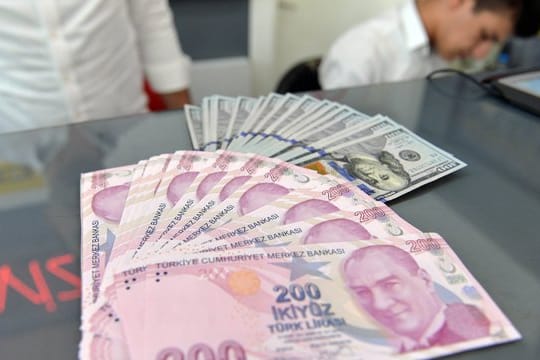 Ein Mitarbeiter einer Wechselstube in Ankara zeigt türkische Lira und US-Dollar.