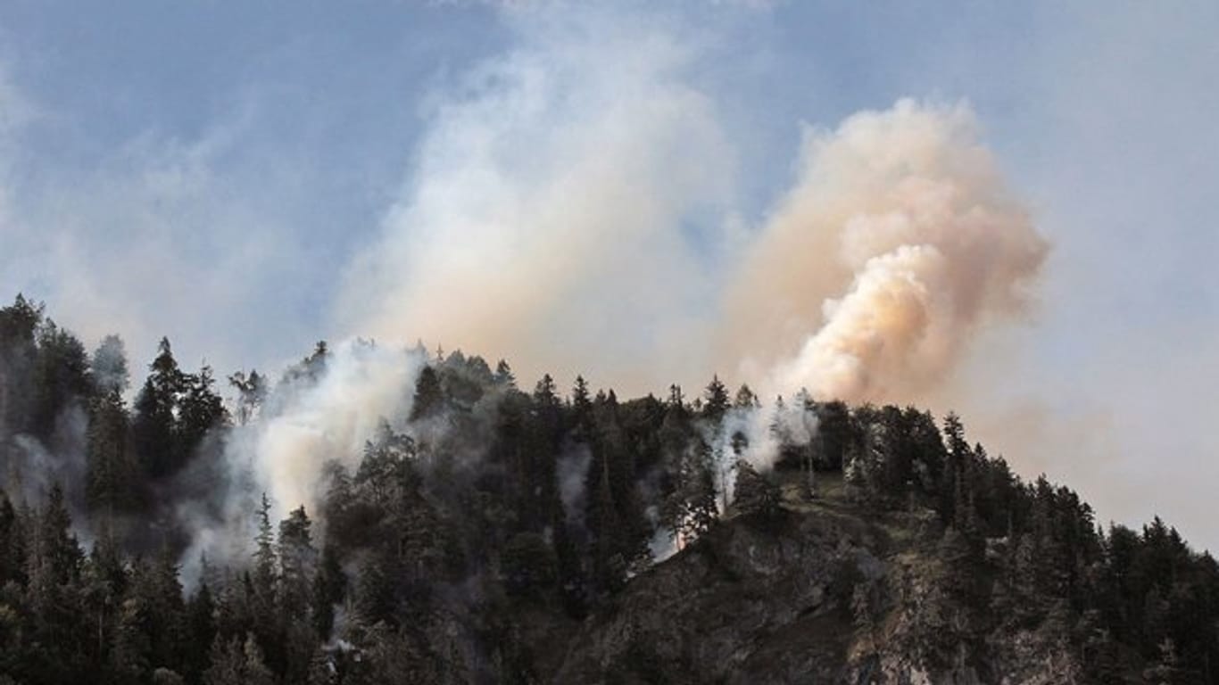 Rauchschwaden ziehen im Landkreis Rosenheim aus einem brennenden Bergwald.