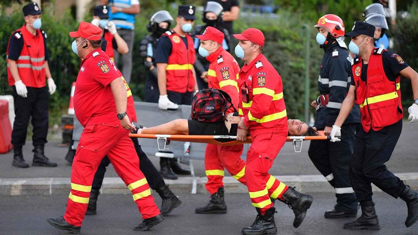 Ein verletzter Demonstrant wird von Rettungskräften mit einer Trage weggebracht: Präsident Klaus Iohannis verurteilte das Vorgehen der Polizei scharf.