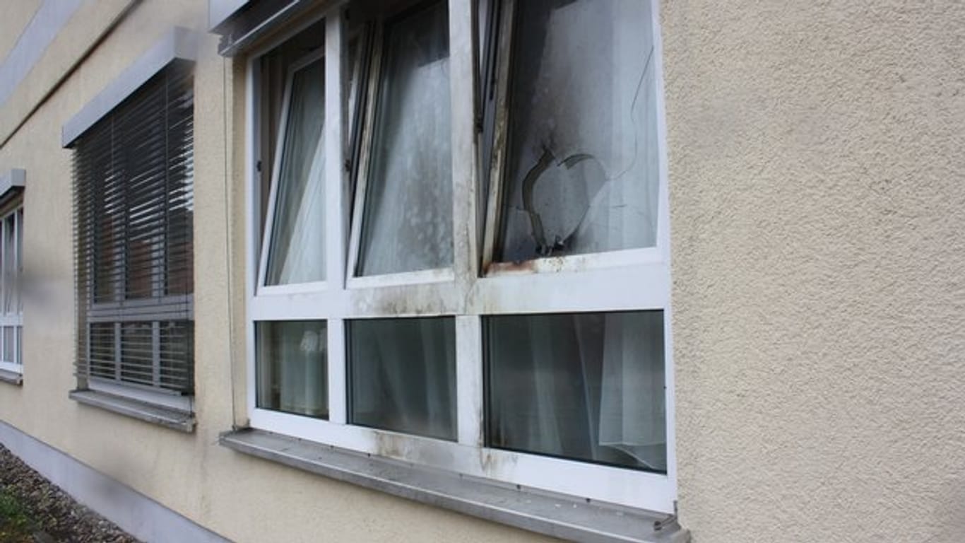 Blick auf ein beschädigtes Fenster nach einem Brandanschlag auf eine Flüchtlingsunterkunft.