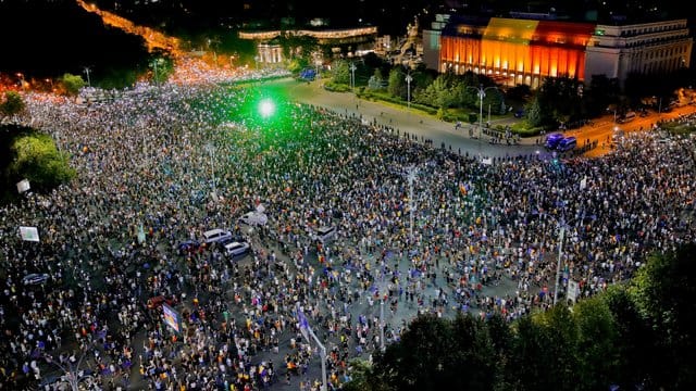 Menschen versammeln sich zu Protesten vor dem Regierungssitz in Bukarest. Menschen versammeln sich zu Protesten vor dem Regierungssitz in Bukarest.