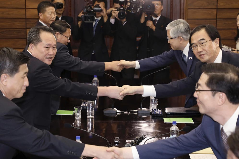 Die Vereinigungsminister aus Nord- und Südkorea (2. Reihe) schütteln sich die Hände: Ihre gemeinsame Stellungnahme bestand aus nur drei Sätzen.