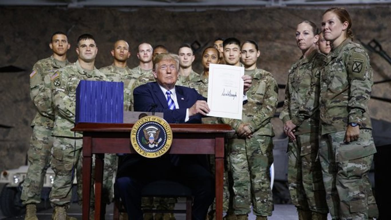 US-Präsident Trump zeigt in der Militärbasis Fort Drum das frisch unterzeichnete Gesetz zum Verteidigungsetat.