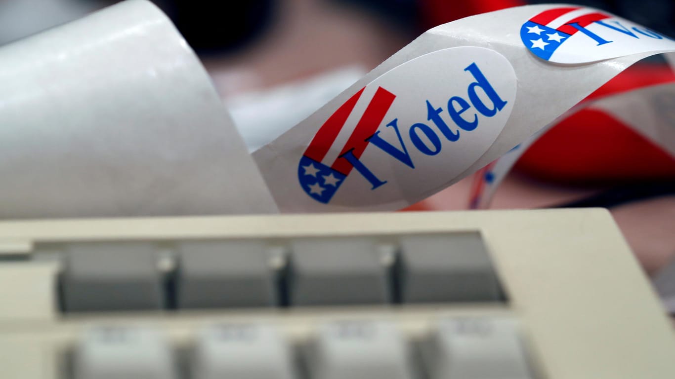 Ein "I voted"-Aufkleber steckt hinter einer Tastatur: Teilnehmer der DEFCON-Konferenz haben vorgeführt, wie leicht sich US-Wahlcomputer austricksen und manipulieren lassen.