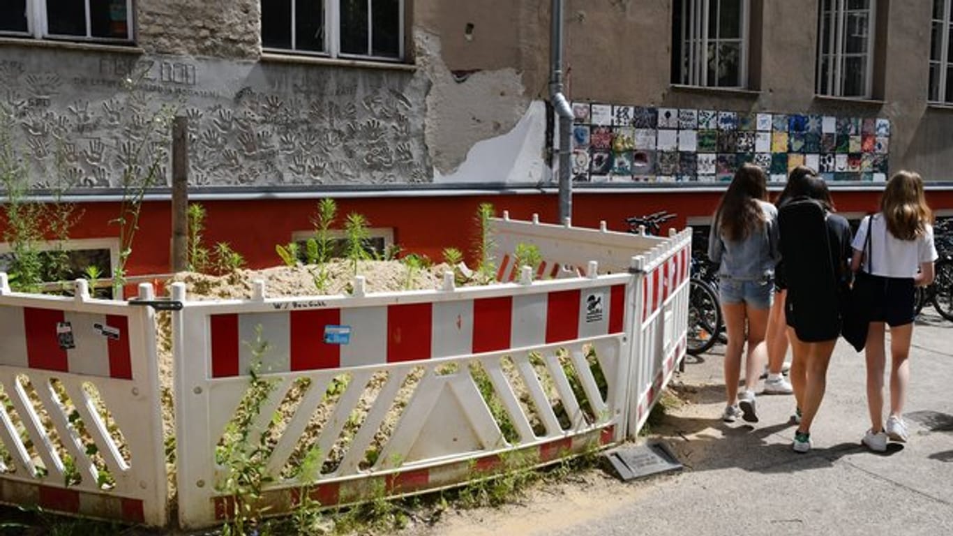 Absperrungen an einer maroden Häuserwand sind auf dem Gelände einer Berliner Schule zu sehen.