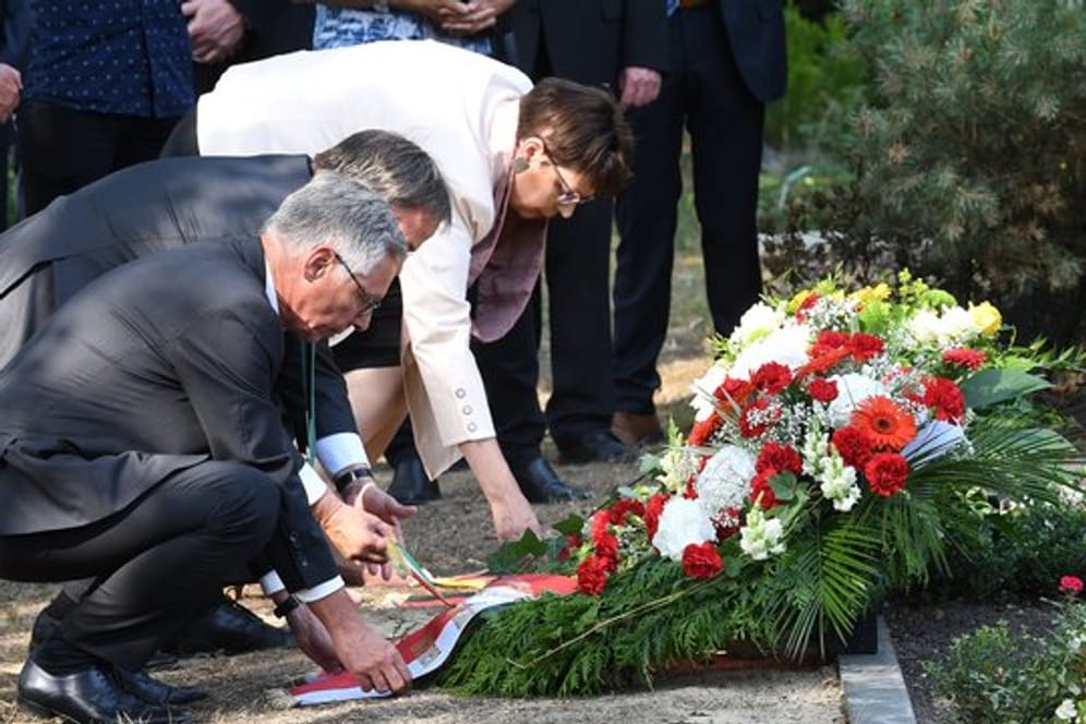 Bremens Bürgermeister Carsten Sieling (SPD), NRW-Ministerpräsident Armin Laschet (CDU) und Birgit Hone legen am Grab der beim Gladbecker Geiseldrama getöteten Silke Bischoff auf dem Friedhof einen Kranz nieder.