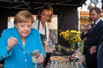 Beim Sommerfest der sächsischen CDU-Landtagsfraktion: Angela Merkel füllt ein Glas mit Gurkensuppe.